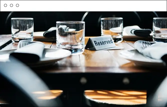 A reserved table sign on a candlelit restaurant table